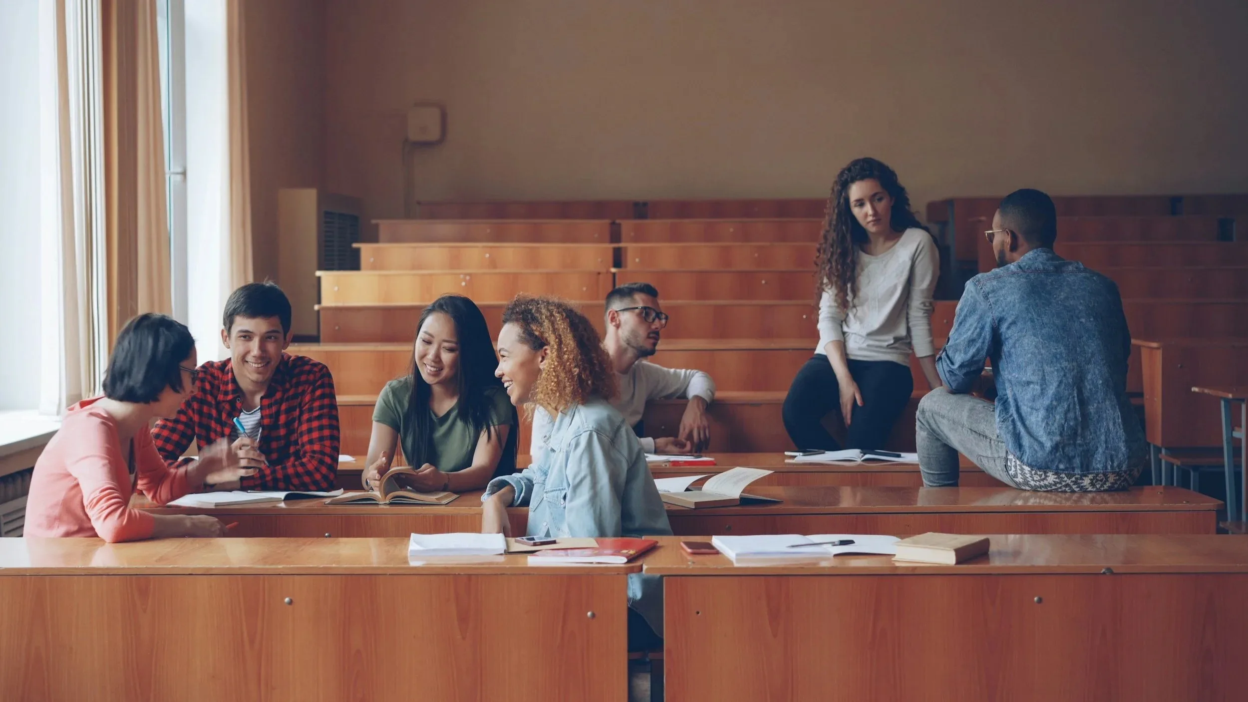 Fellows in conversation in a lecture hall